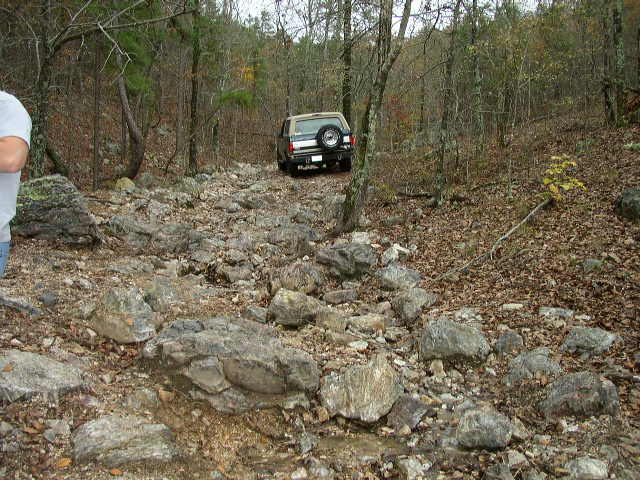 1995 Ford Bronco rear view on a rocky, wooded trail