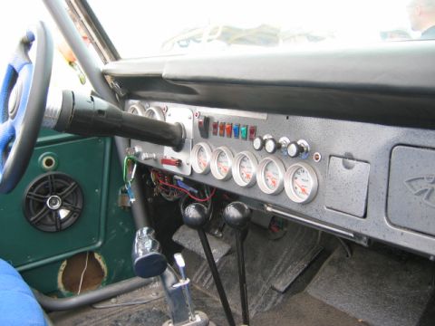 1985 Ford Bronco - Custom dashboard with auxiliary gauges and switches, and a roll cage visible.