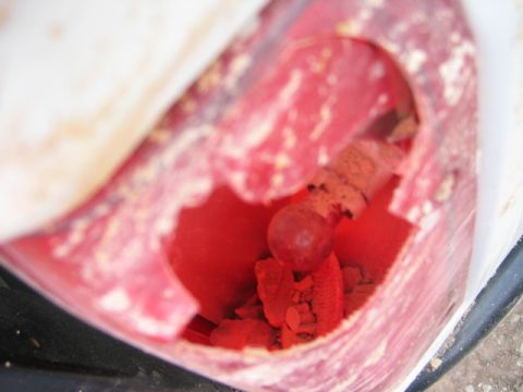 1985 Ford Bronco - The contents of a red plastic container appear to be a red powder with a spherical object.