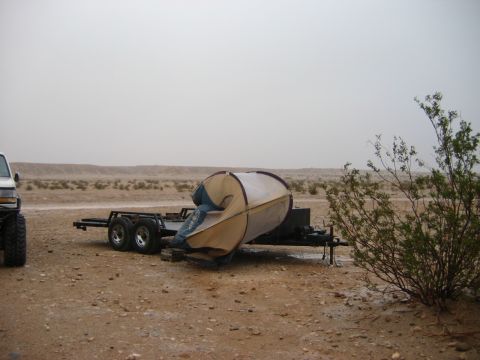 1985 Ford Bronco - Setting up a tent on a trailer in a desert environment with a truck nearby.