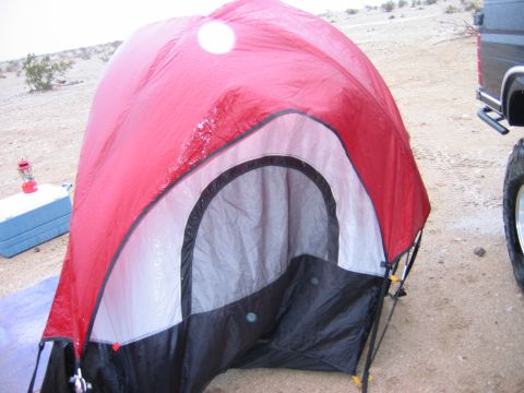 1985 Ford Bronco - A tent is pitched in a dry, sandy area with a vehicle visible to the right.