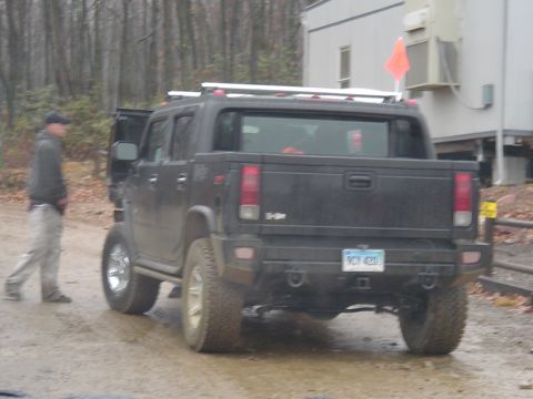 1993 Ford Bronco - A black SUV is parked on a dirt road with a man standing next to the open driver's door.