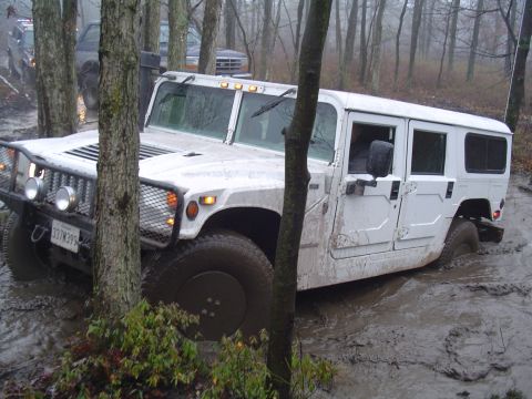 1993 Ford Bronco - White Hummer H1 stuck in mud off-road, with another vehicle in the background.