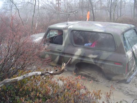 1993 Ford Bronco - This camouflage-clad 1978 Ford Bronco is deep in the mud, with its tires submerged in the mire.