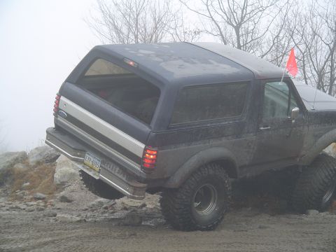 1993 Ford Bronco - This SUV is seen on a foggy, rocky terrain with large off-road tires.
