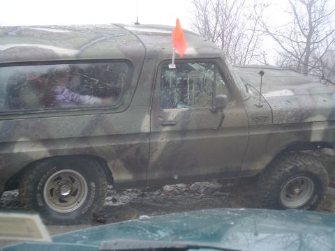 1993 Ford Bronco - This camouflaged SUV is stuck in the mud, with an orange flag attached to its roof.