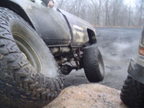1993 Ford Bronco - A 1993 Ford Bronco is shown in a muddy, off-road setting with another vehicle nearby.