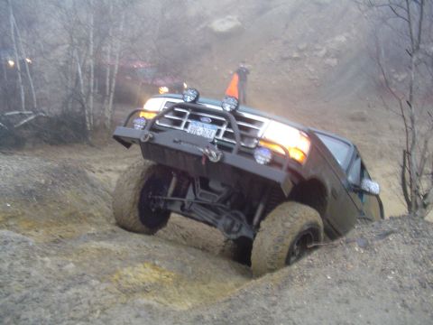 1993 Ford Bronco - This Ford Bronco is tackling a challenging off-road course, demonstrating its capabilities on rough terrain.