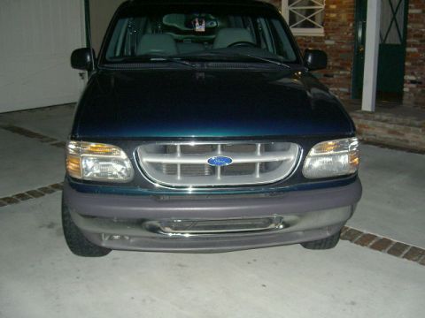 1996 Ford Explorer - Dark green Ford Explorer's front end is shown in a driveway.