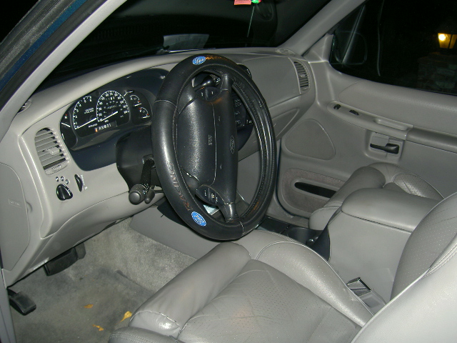 Gray leather interior and gauge cluster of a 1990s Ford SUV, driver's side