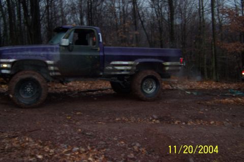 1979 Ford Bronco - A lifted pickup truck sits on a muddy path surrounded by trees, with a date stamp visible in the corner.