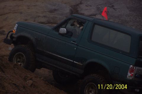 1979 Ford Bronco - This Ford Bronco is navigating a rocky incline, with a red flag attached to its roof.