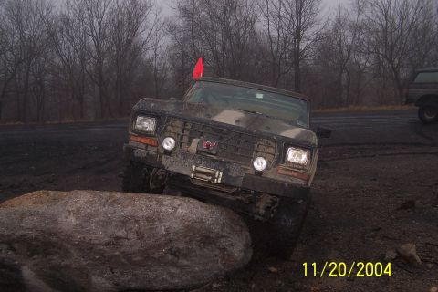1979 Ford Bronco - This 1979 Ford Bronco, sporting camouflage paint, tackles a challenging off-road obstacle.