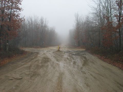 1995 Ford Bronco - A foggy day obscures a muddy intersection of dirt roads surrounded by bare trees.