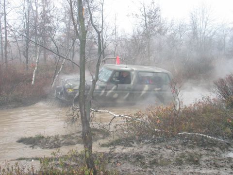 1995 Ford Bronco - This camouflaged 1978 Ford Bronco navigates through a muddy, off-road terrain.