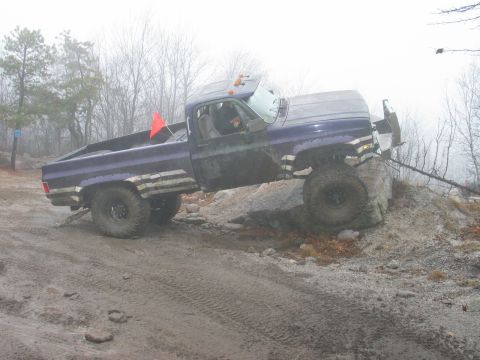 1995 Ford Bronco - A modified pickup truck navigates a challenging off-road course on a foggy day.