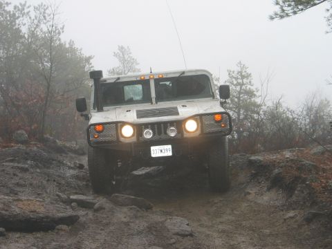 1995 Ford Bronco - A Hummer H1 navigates a challenging off-road course on a foggy day.