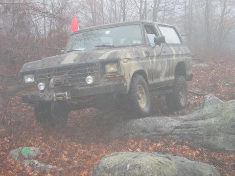 1995 Ford Bronco - This vintage Ford Bronco navigates a rocky trail amidst a misty forest setting.