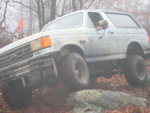 1995 Ford Bronco - Ford Bronco navigating rough terrain with an orange flag visible in the background.