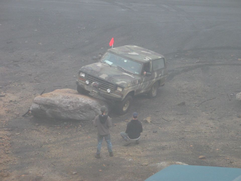 Camouflaged Ford Bronco on a rock, front-left tire elevated