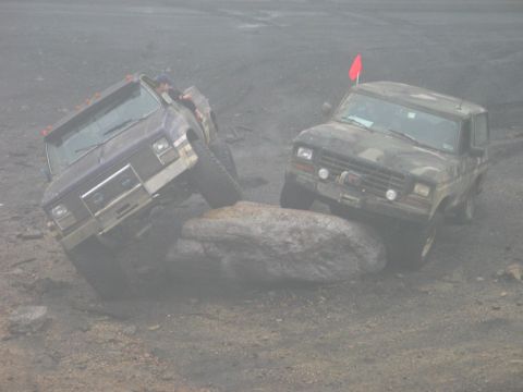 1995 Ford Bronco - Two Ford Broncos tackle a challenging rock obstacle during an off-road excursion.