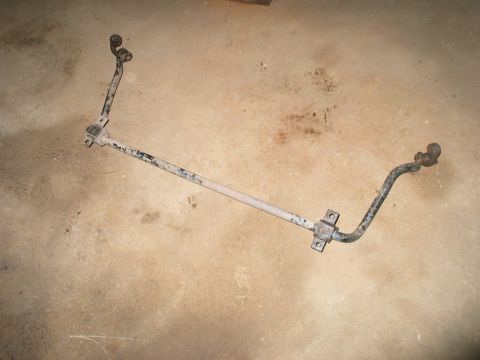 1995 Ford Bronco - A used suspension stabilizer bar lies on a concrete surface.