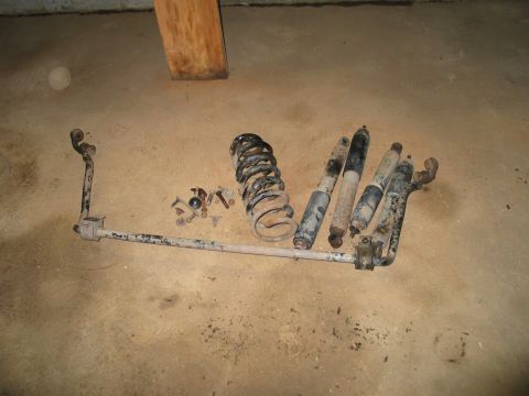 1995 Ford Bronco - Collection of used vehicle suspension parts, including shocks, springs, and sway bar components.