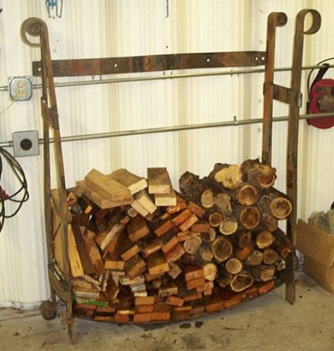 1990 Ford Bronco - A metal firewood rack holds a large quantity of split logs and whole logs, ready for use.