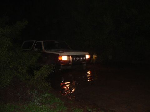 1990 Ford Bronco - This 1990 Ford Bronco is navigating through water in the dark.