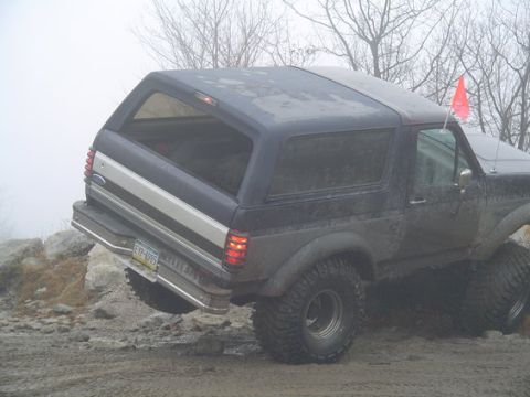 1995 Ford Bronco - This 1992 Ford Bronco is shown from the rear 3/4 angle on a challenging off-road course.