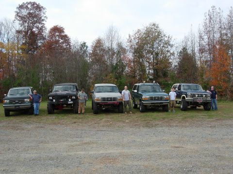1995 Ford Bronco - Several Ford Broncos and F-Series trucks are lined up in a row outdoors.