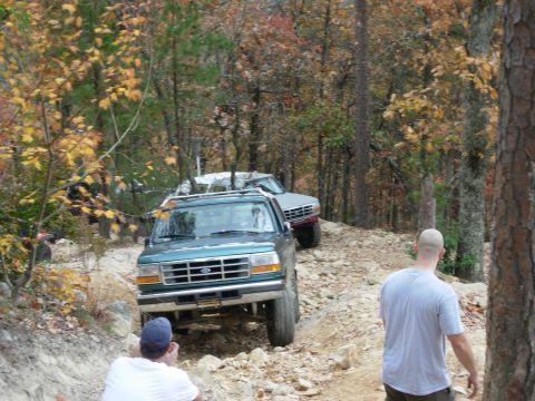 1995 Ford Bronco - Two SUVs navigate a challenging off-road trail during an autumn outing.