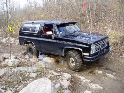 1992 Ford Bronco - This black SUV is equipped for off-road driving, with large tires and a brush guard on the front.