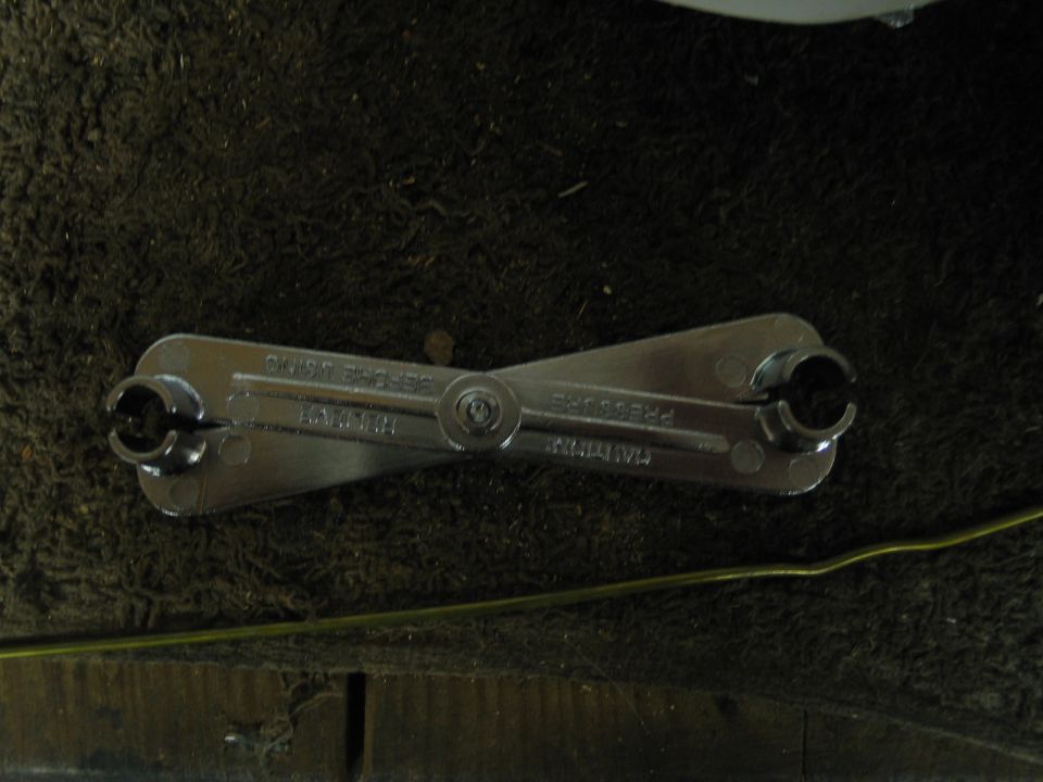 Folding dual-end box wrench tool on dark carpet