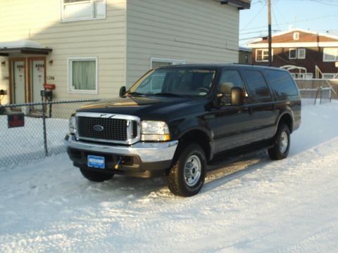 2004 Ford Excursion - Black 2004 Ford Excursion parked in front of a house during winter.