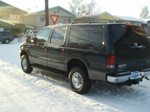 2004 Ford Excursion - A black Ford Excursion is parked in a snowy residential area, seen from the rear three-quarter angle.