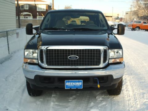 2004 Ford Excursion - Black Ford Excursion parked in a snowy area, front view.