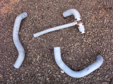 1991 Ford LTD Crown Victoria - Three light blue radiator hoses are laid out on a gravel surface. One hose features a metal connector.
