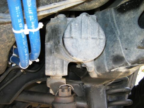 1985 Ford Bronco - Close-up view of a vehicle's power steering gearbox and associated hoses.