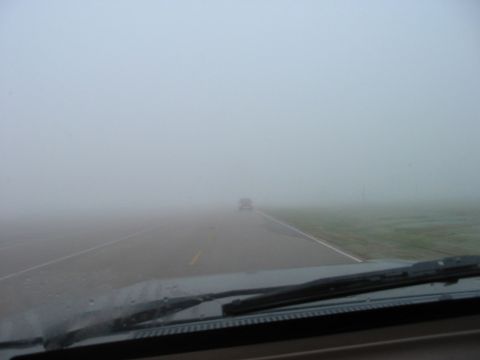 1988 Ford Bronco - Driving through dense fog with another vehicle visible in the distance on the road ahead.