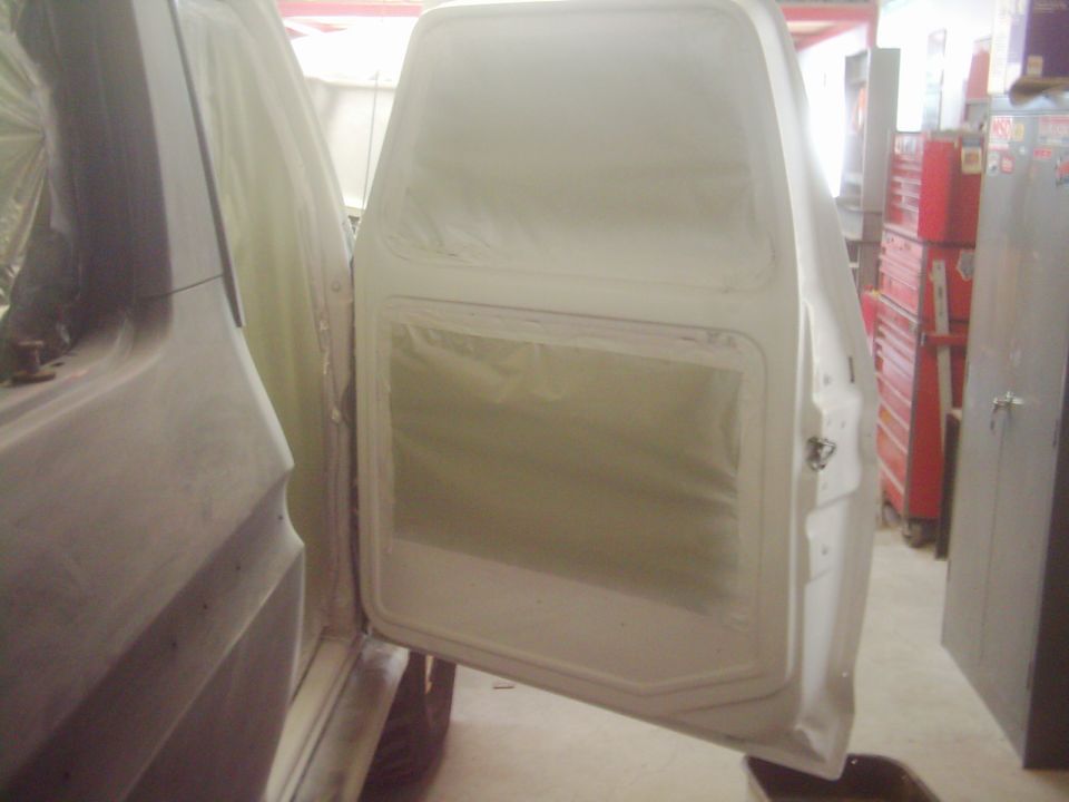 Car door and body panel covered in masking paper, interior of door visible
