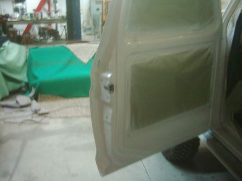 1978 Ford Bronco - A car door is prepped for painting in a workshop environment.