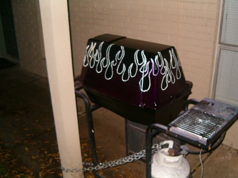 1996 Ford Bronco - A custom-painted grill with flame decals sits on a stand next to a propane tank.