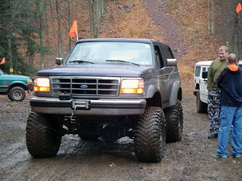 1979 Ford Bronco - This dark blue SUV, likely a 1992 Ford Bronco, is equipped with large off-road tires and a front winch.