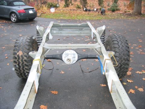 1978 Ford Bronco - A bare truck frame during a restoration, stripped down to the rails with the rear differential/axle housing and leaf-spring mounts exposed,…