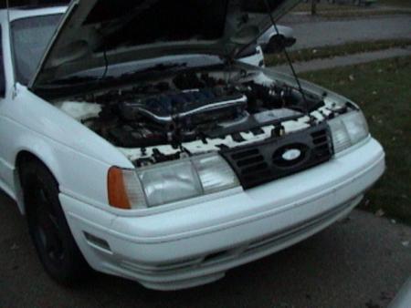 1990 Ford Taurus - Front view of a 1990 Ford Taurus with the hood open.