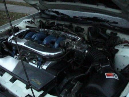 1990 Ford Taurus - Close-up of a car's engine compartment, showing the intake manifold and air filter assembly.