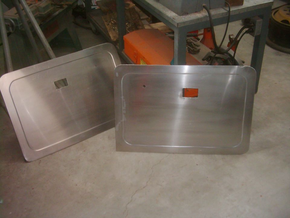 two brushed aluminum door panels, one with an orange reflector