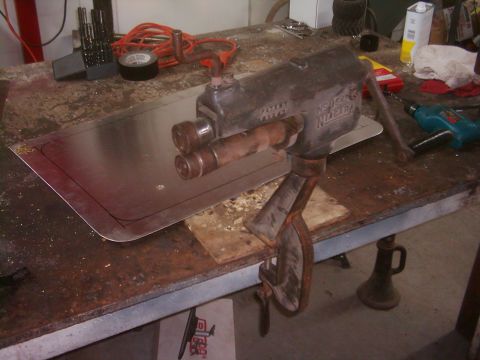 1978 Ford Bronco - A bead roller machine is clamped to a workbench, ready to shape a piece of sheet metal.