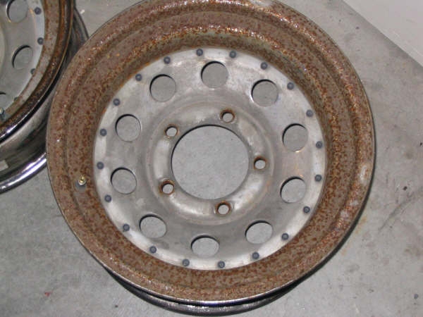 rusty steel wheel with multiple lug nut holes